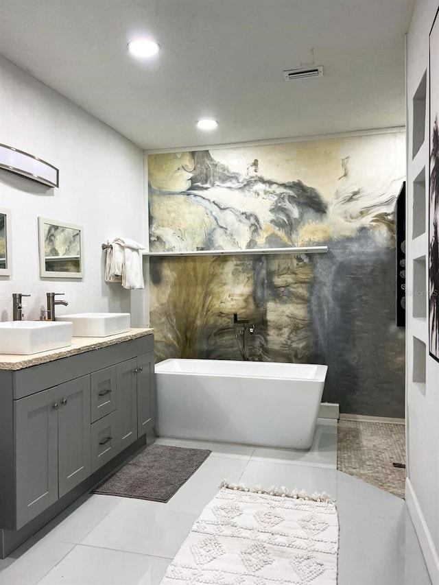 bathroom featuring tile patterned flooring, a bathtub, and vanity