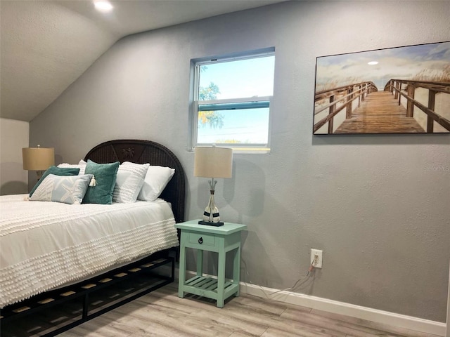 bedroom featuring wood-type flooring and vaulted ceiling