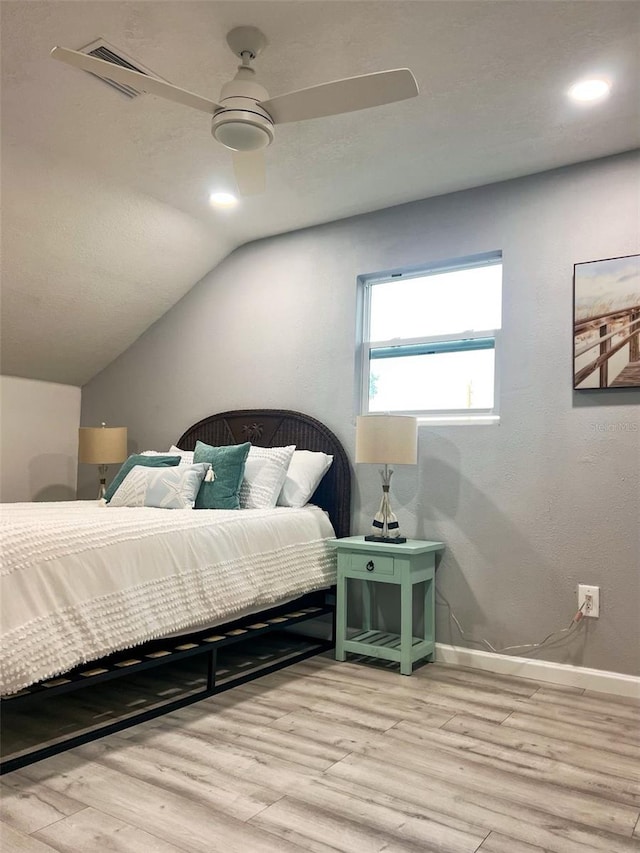 bedroom featuring ceiling fan, light hardwood / wood-style floors, and vaulted ceiling