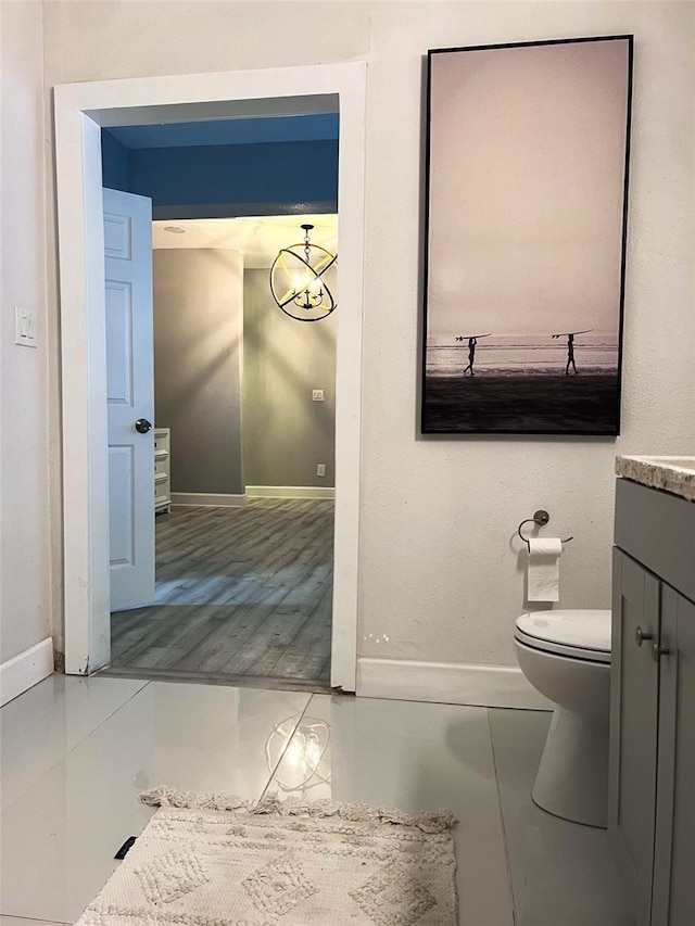 bathroom with toilet, vanity, and an inviting chandelier