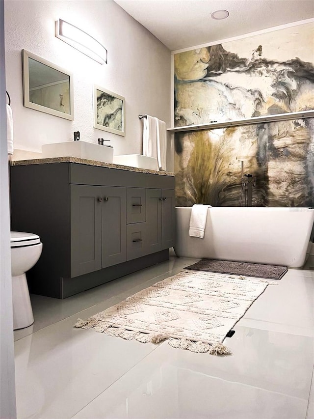 bathroom featuring vanity, toilet, and a tub to relax in