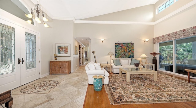 foyer entrance featuring a notable chandelier, high vaulted ceiling, and french doors