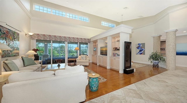 living room with a towering ceiling and light hardwood / wood-style floors