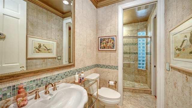 bathroom featuring a shower with door, crown molding, sink, tile patterned flooring, and toilet