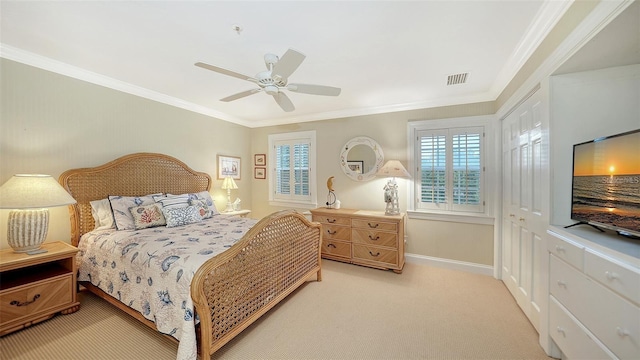 carpeted bedroom featuring ceiling fan, crown molding, and a closet