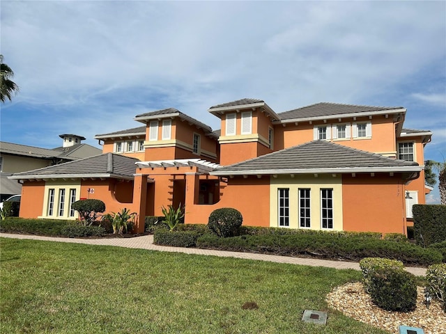 prairie-style home featuring a pergola and a front lawn