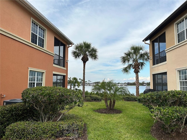 view of yard with central air condition unit and a water view