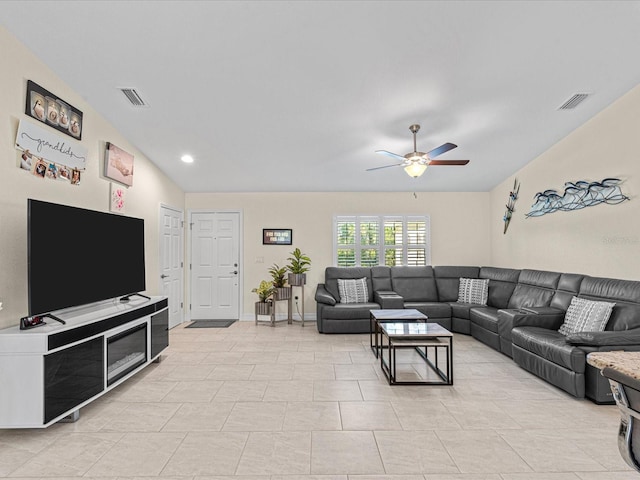 living room featuring ceiling fan, light tile patterned floors, and vaulted ceiling