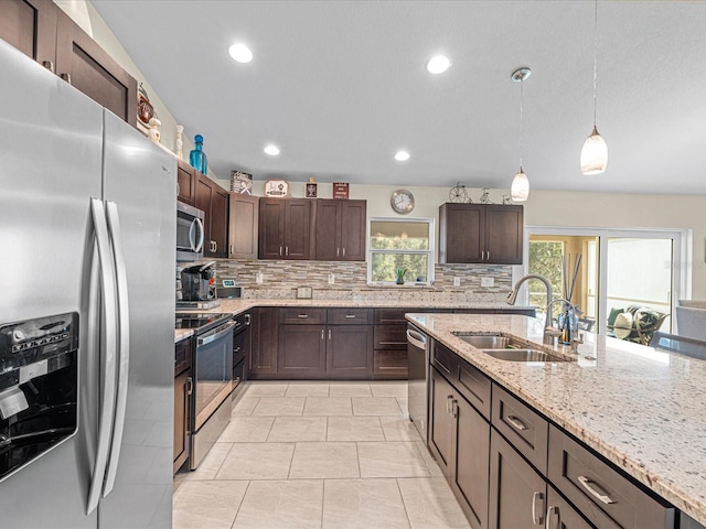 kitchen with backsplash, sink, hanging light fixtures, dark brown cabinetry, and stainless steel appliances