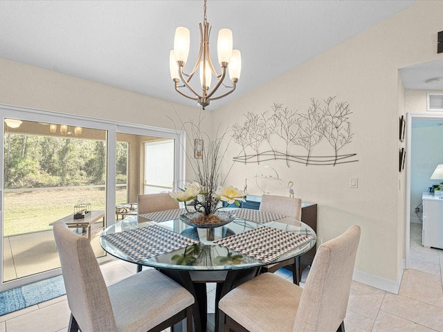 dining space featuring washer / clothes dryer, light tile patterned floors, and a chandelier