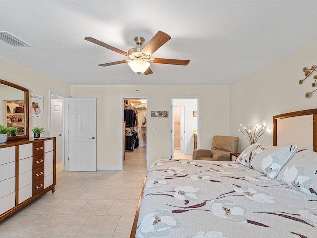 bedroom with a spacious closet, a closet, ceiling fan, and ensuite bathroom