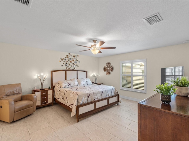 tiled bedroom featuring ceiling fan and a textured ceiling