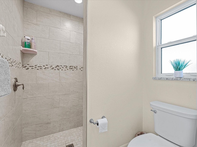 bathroom with tiled shower and toilet