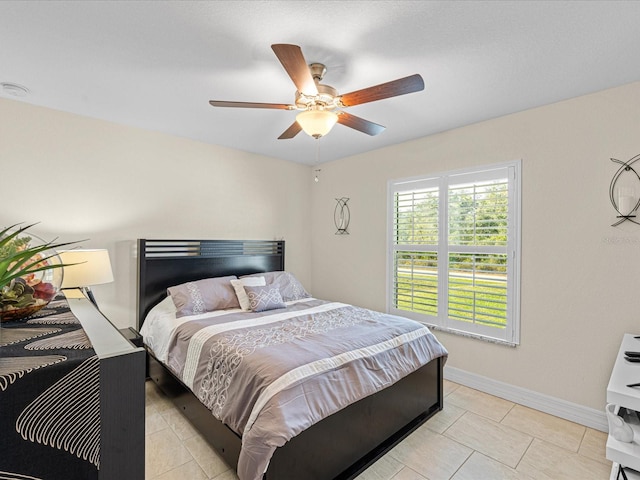 tiled bedroom featuring ceiling fan