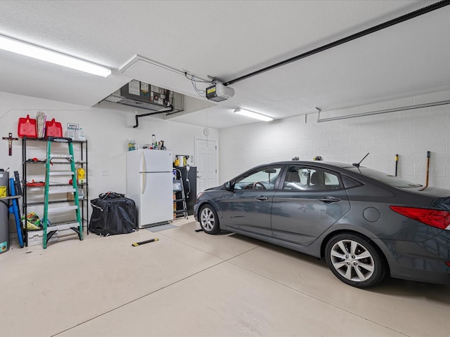 garage with white fridge and a garage door opener