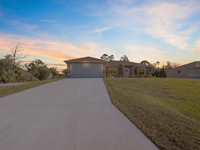 ranch-style house featuring a garage and a lawn