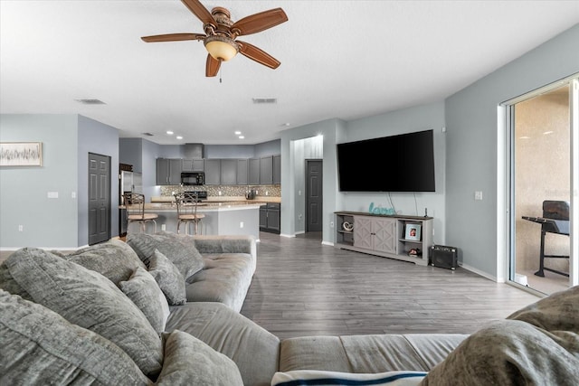 living room featuring ceiling fan and light hardwood / wood-style flooring