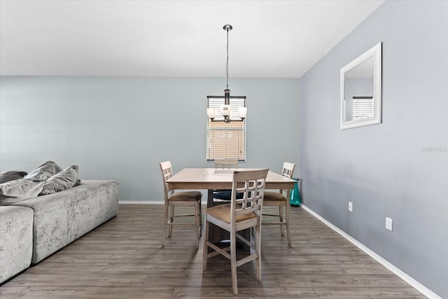 dining space featuring hardwood / wood-style flooring and a notable chandelier