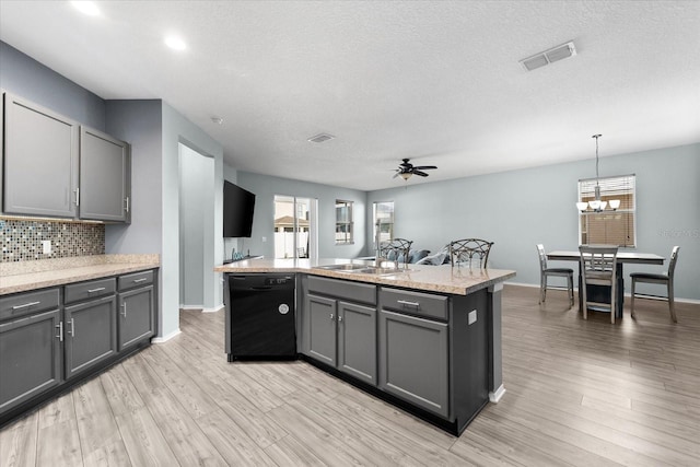 kitchen with a kitchen island with sink, pendant lighting, gray cabinets, and dishwasher