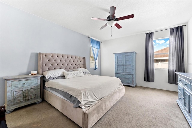 carpeted bedroom with ceiling fan and a textured ceiling