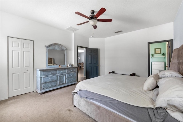 carpeted bedroom featuring a textured ceiling, a closet, and ceiling fan