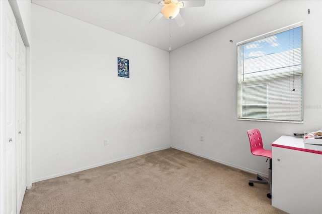 unfurnished office featuring light carpet and ceiling fan