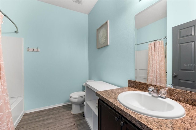 full bathroom featuring vanity, hardwood / wood-style flooring, toilet, and shower / bath combo with shower curtain