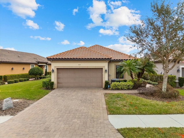 mediterranean / spanish-style house with a front yard and a garage