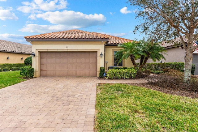 mediterranean / spanish house with a front yard and a garage