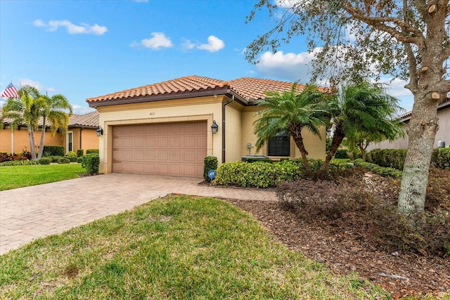 mediterranean / spanish-style house with a garage and a front lawn