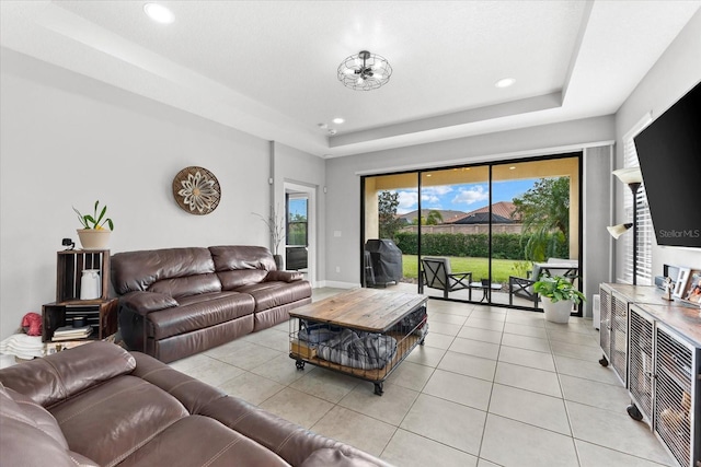 living room featuring light tile patterned floors and a tray ceiling