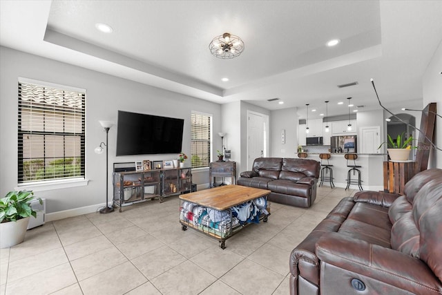 living room featuring light tile patterned floors and a raised ceiling