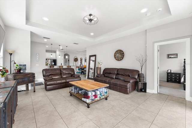 living room featuring light tile patterned floors and a tray ceiling