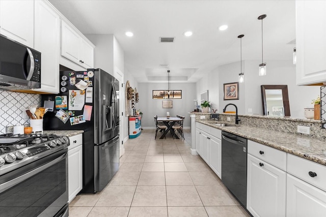 kitchen with appliances with stainless steel finishes, hanging light fixtures, light stone countertops, white cabinets, and sink