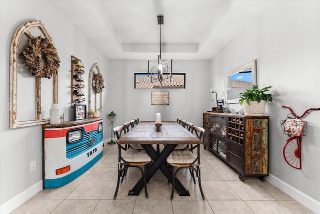 dining room featuring plenty of natural light, light tile patterned floors, a raised ceiling, and a notable chandelier