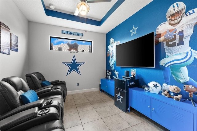 living room with a raised ceiling, light tile patterned floors, and ceiling fan