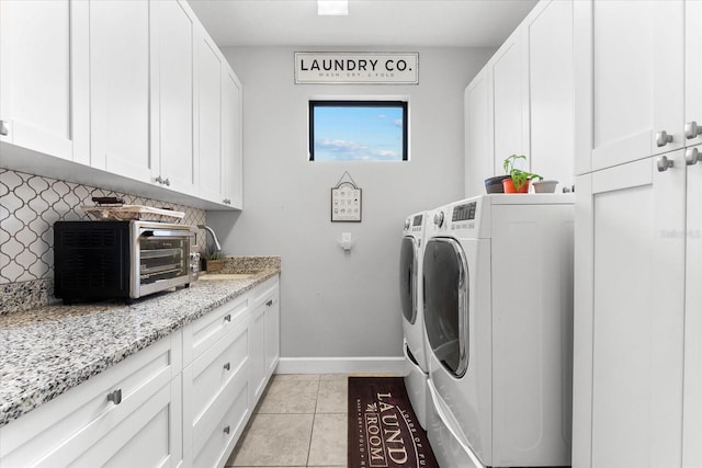 laundry room featuring washing machine and dryer, cabinets, light tile patterned floors, and sink