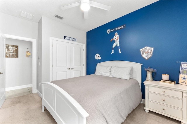 bedroom featuring ceiling fan, a closet, and light carpet