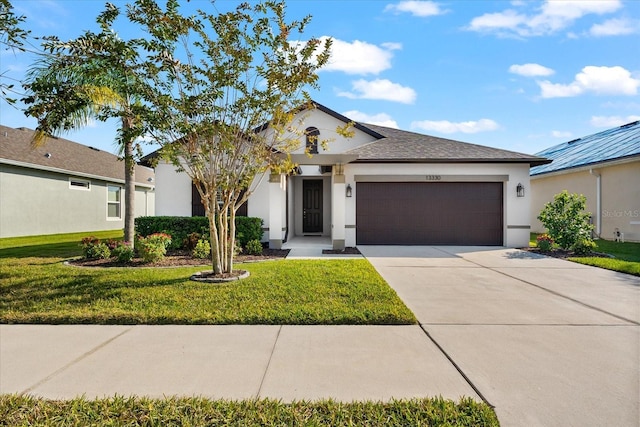 view of front of property featuring a front yard and a garage