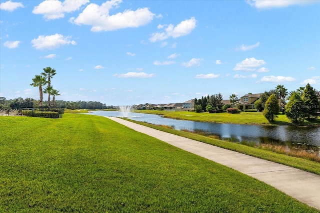 surrounding community with a water view and a yard