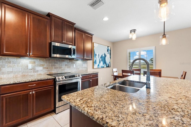 kitchen with tasteful backsplash, sink, light stone countertops, and appliances with stainless steel finishes