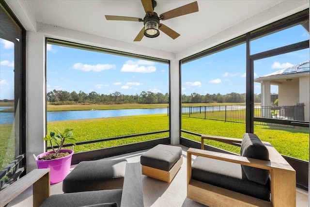 sunroom featuring ceiling fan and a water view