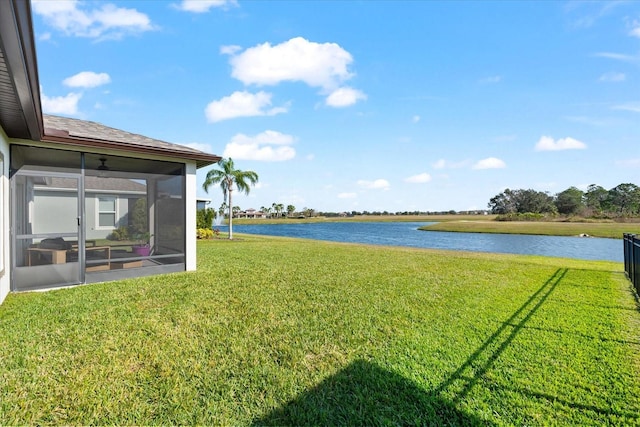 view of yard with a sunroom and a water view