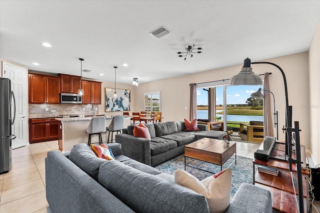 living room with light tile patterned floors and a water view