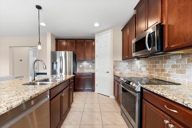 kitchen featuring light tile patterned flooring, appliances with stainless steel finishes, decorative light fixtures, sink, and decorative backsplash