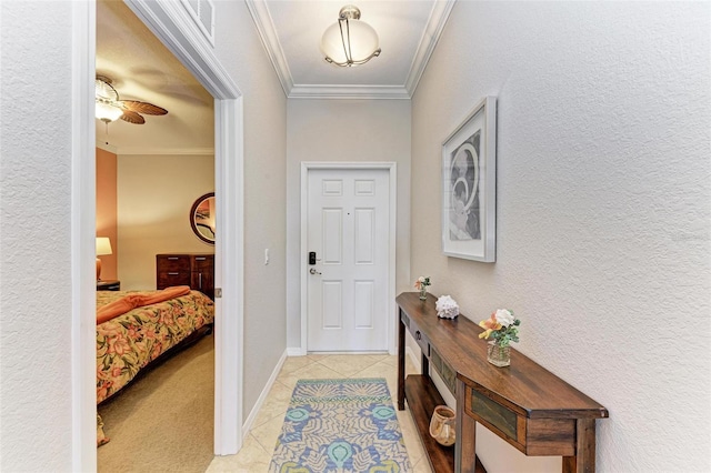 entryway with ceiling fan, ornamental molding, and light tile patterned floors