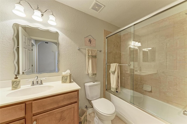 full bathroom with tile patterned floors, a textured ceiling, combined bath / shower with glass door, toilet, and vanity