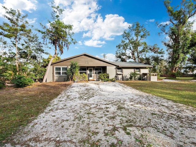 ranch-style house with a porch and a front lawn