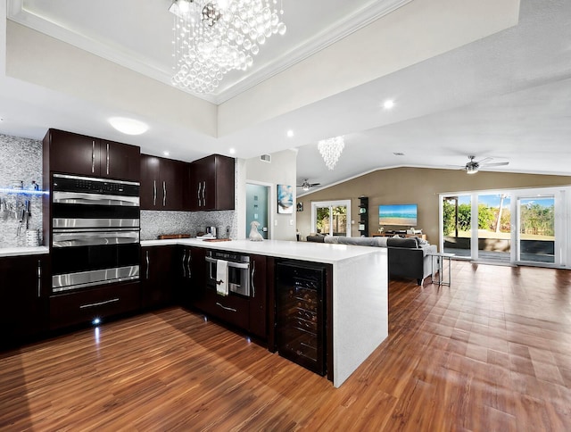 kitchen featuring stainless steel double oven, dark brown cabinetry, beverage cooler, and kitchen peninsula