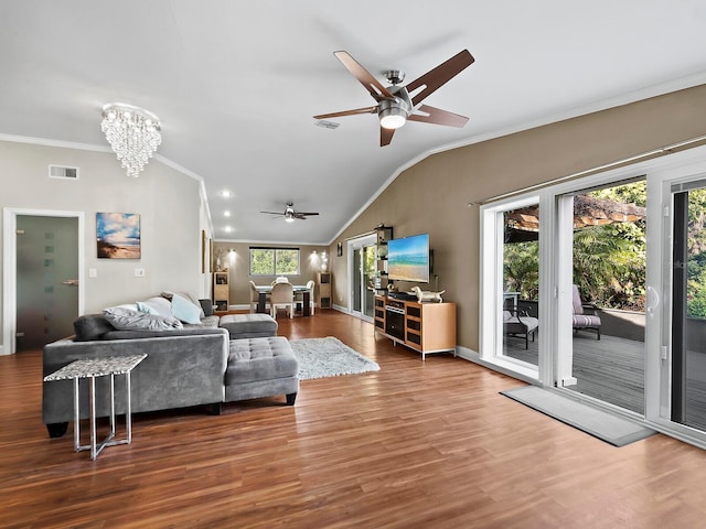 living room with ceiling fan with notable chandelier, ornamental molding, lofted ceiling, and hardwood / wood-style floors